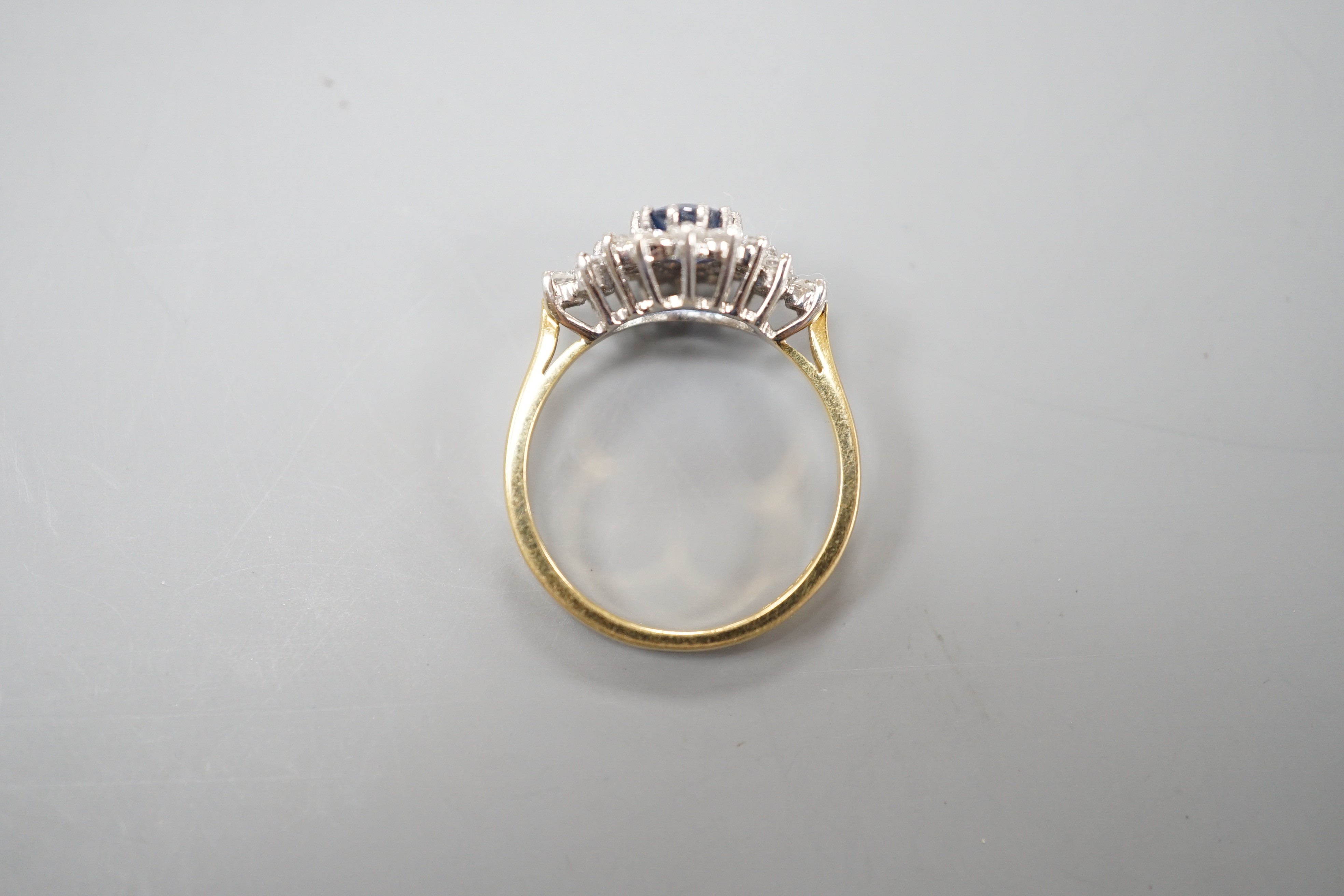 A modern 18ct gold, sapphire and diamond set elliptical shaped cluster dress ring, size N, gross weight 3.5 grams